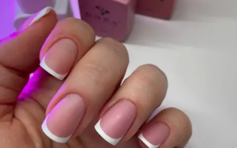 Dłonie z idealnym manicure, klasyczny french na paznokciach.