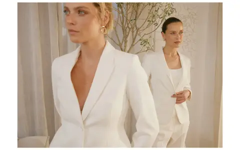 Dwie kobiety w białych garniturach, uosobienie power dressingu. Eleganckie, pewne siebie, gotowe na podbój świata.