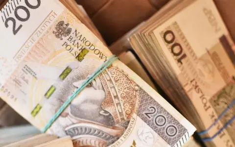 Stosy polskich banknotów 200 zł i 100 zł. Zastanawiasz się, ile zarabia sprzedawca w salonie samochodowym?