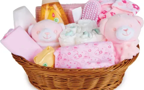 En korg fylld med rosa babyartiklar, inklusive nallar, blöjor och tvättlappar, perfekt som baby shower present.