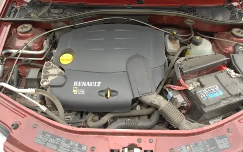Silnik Renault 1.5 dCi w samochodzie, widoczny akumulator i przewody.