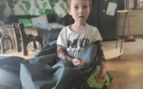 Chłopiec w koszulce "NO HOT" siedzi w worku sako. Czy zaburzenia integracji sensorycznej to autyzm?