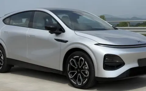 Srebrny SUV XPENG G6 z czarnymi felgami na tle krajobrazu.