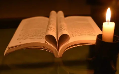 Otwarta księga z sercem z kartek, obok płonąca świeca. "Pan jest pasterzem moim" - tekst w sercu.