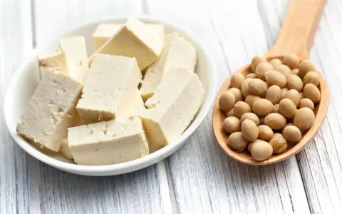 Kostki białego tofu w miseczce i łyżka pełna ziaren soi. Idealne składniki na zdrowe posiłki, w tym tofu dla niemowlaka.