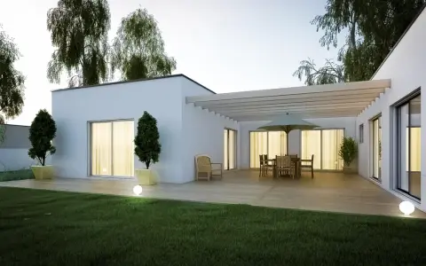 Une terrasse moderne avec mobilier de jardin et pergola, entourée d'un jardin verdoyant et d'arbres. Une extension de maison qui invite à la détente, parmi les plus belles extensions de maison.