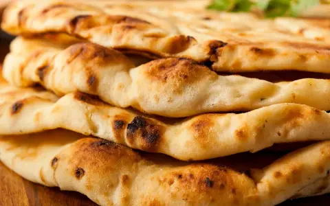 Gestapeltes, frisch gebackenes Naan Brot mit leichten Röststellen. Perfekt zum Dippen!