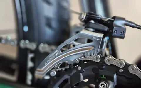 Zbliżenie na przednią przerzutkę rowerową Shimano Deore. Dowiedz się, jak zmieniać przerzutki w rowerze, by jazda była płynniejsza.