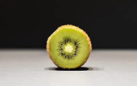 Połówka kiwi, idealna na keto, z widocznymi czarnymi pestkami i zielonym miąższem.