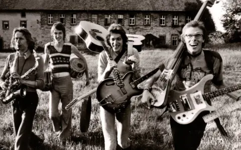 Vier Musiker mit Gitarren und Saxophon, ein Schlagzeuger. Eine Szene, die an deutsche Bands der 70er erinnert, voller Energie und Musik.