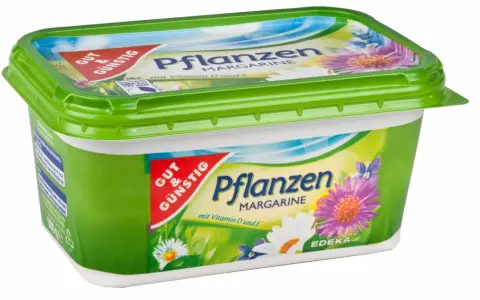 Grüne Margarine-Packung mit Blumenmotiv. Sie besteht aus Pflanzenöl und enthält Vitamine D und E.