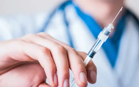 Dłoń trzymająca strzykawkę z heparyną. Pytanie: gdzie wyrzucić strzykawki po heparynie? Bezpieczne utylizowanie jest kluczowe.
