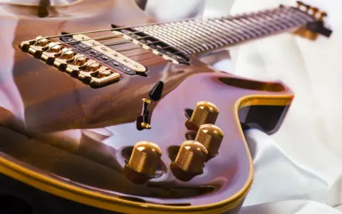 Glänzende E-Gitarre mit goldenen Details, bereit, um das Gitarre lernen zu beginnen.