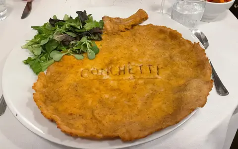 Cosa mangiare a Milano? Una cotoletta gigante con insalata fresca, un classico da provare assolutamente!
