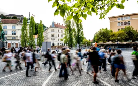 Menschen beleben den Platz, ein Beispiel für eine 15-Minuten-Stadt, die Bewegungsfreiheit und Gemeinschaft fördert.