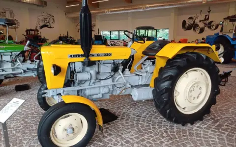 Żółty Ursus C-330, idealny ciągnik na 30 ha, prezentowany w muzeum.