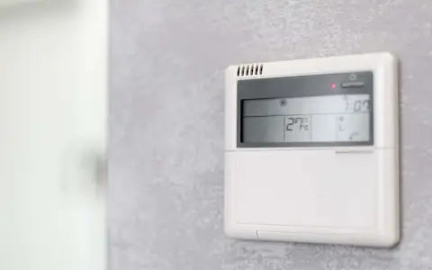 Panel klimatyzacji hotelowej pokazuje 27°C. Dowiedz się, jak ustawić klimatyzację w hotelu, by cieszyć się komfortem.