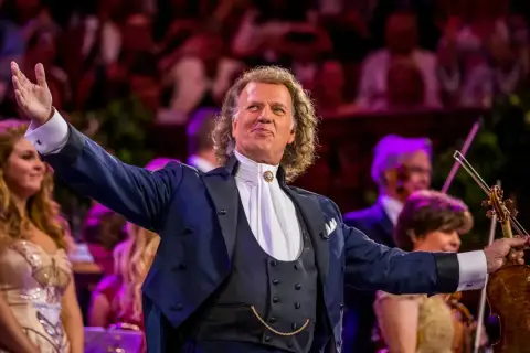 André Rieu w Polsce, dyrygent z wirtuozerską skrzypaczką wita publiczność.