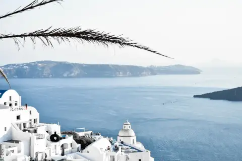 Santorini, Grecja. Białe domy na klifie, błękitne morze i wyspy w oddali. Ciekawe miejsca i widoki.
