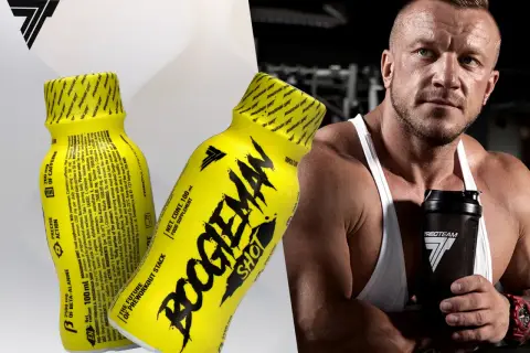 Mężczyzna z potężną sylwetką trzyma shaker, obok niego żółte shoty "Boogieman Shot" - napój dla sportowców.