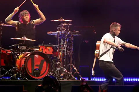 Tyler Joseph śpiewa, a Josh Dun gra na perkusji podczas koncertu twenty one pilots.