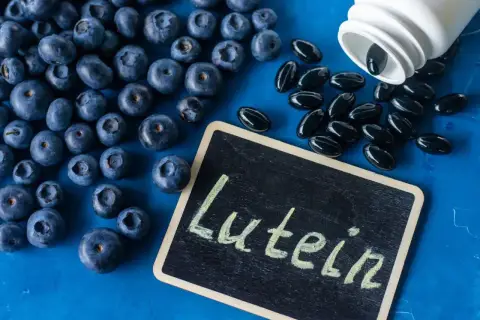 Jagody i kapsułki z luteiną na oczy. Luteina wspiera zdrowie wzroku, a jagody są jej naturalnym źródłem.