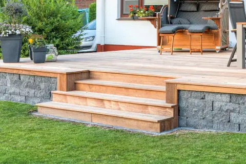 Eine schöne Holztreppe mit 2 Stufen, die man leicht selber bauen kann, führt zur Terrasse.