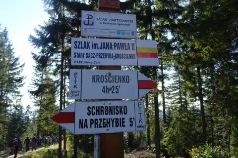 Znaki szlaków w Beskidzie Sądeckim. Szlak im. Jana Pawła II prowadzi do Krosna i schroniska na Przehybie.
