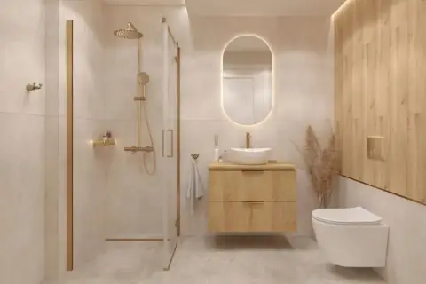Nowoczesna łazienka z prysznicem, wiszącą szafką i toaletą. Złote baterie i detale nadają elegancji. Idealne miejsce, by pomyśleć, jakie IP do łazienki będzie najlepsze.