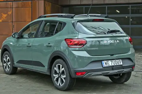Dacia Sandero w zielonym kolorze lakieru, z relingami dachowymi, prezentuje się nowocześnie.