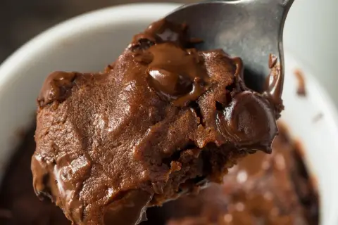 Łyżka z porcją pysznej, pieczonej owsianki brownie z roztopioną czekoladą.