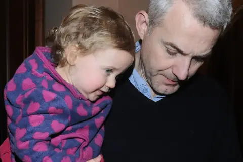 Hubert Urbański z córką, która przytula się do niego w bluzie w serduszka.