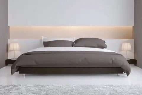 Elegante camera da letto con letto moderno e testata letto cartongesso illuminata, comodini con lampade e tappeto soffice.