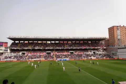 Mecz na madryckim stadionie. Piłkarze biegają po zielonej murawie, a trybuny wypełniają kibice.