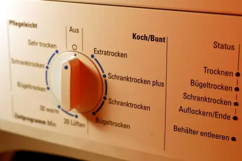 Bedienfeld eines Wäschetrockners mit verschiedenen Programmen wie "Schranktrocken" und "Bügeltrocken" für die Wäsche, inklusive sportklamotten trockner.