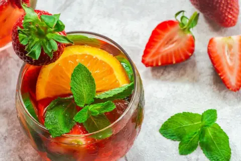 Orzeźwiający drink z truskawkami, pomarańczą i miętą, idealny do prosecco brut.