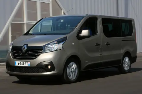 Szary Renault Trafic 3 w ruchu, z widocznym kierowcą za kierownicą.
