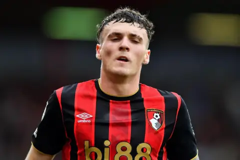 Piłkarz AFC Bournemouth w czerwono-czarnej koszulce, gotowy na kolejne bournemouth transfery.