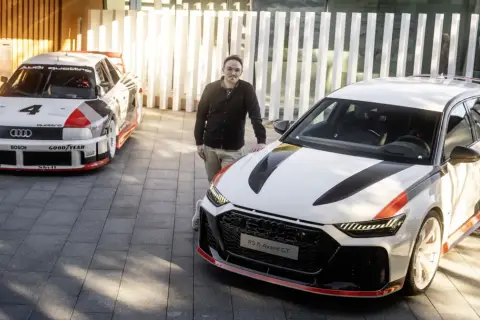 Mężczyzna stoi obok nowoczesnego Audi RS6 Avant GT, a w tle historyczny Audi Quattro.
