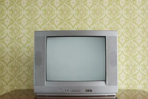 Stary kineskop na tle tapety w zielone wzory. Czekał na ulubiony program.