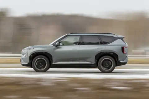 Szary Kia EV5 w ruchu, z rozmytym tłem sugerującym prędkość.