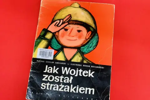 Okładka książki "Jak Wojtek został strażakiem" z ilustracją chłopca w hełmie.