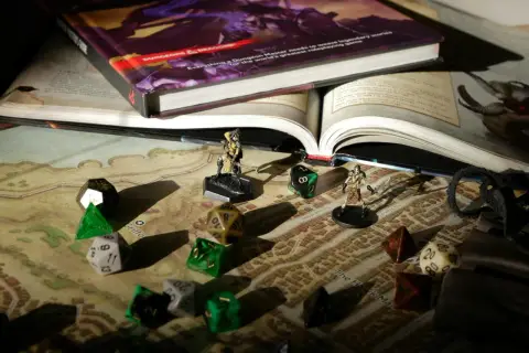Kości, figurki i podręcznik Dungeons & Dragons na mapie. Przygotowania do epickiej gry fabularnej.