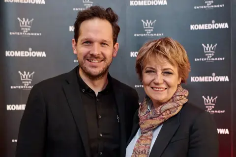 Rafał Pacześ z partnerką, uśmiechnięci na ściance.