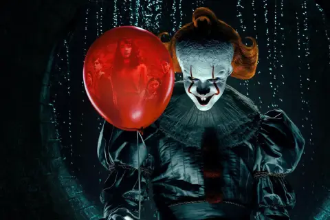 Przerażający klaun Pennywise trzyma czerwony balon, w którym widać grupę dzieci. To jeden z najlepiej ocenianych horrorów.