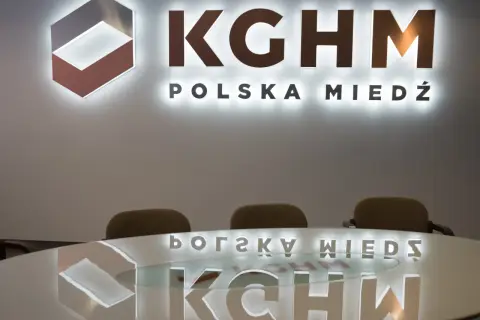 Logo KGHM Polska Miedź i odbicie na stole. Czy Konfederacja poprze ustawę o obniżeniu podatku miedziowego w zamian za ustępstwa?