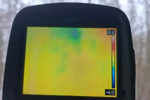 Ekran kamery termowizyjnej E60 pokazuje rozkład temperatur. Badanie kamerą termowizyjną ujawnia chłodniejsze obszary w zielono-niebieskim paśmie.