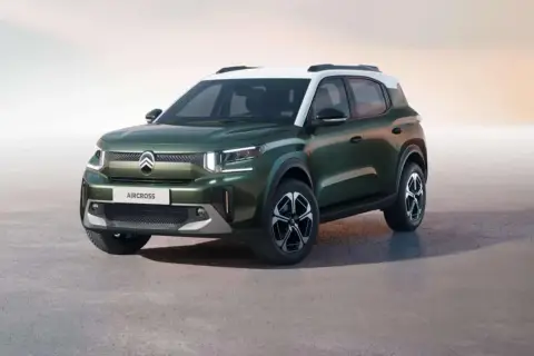 Zielony Citroën Aircross z białym dachem, stojący na szarym podłożu.
