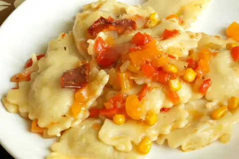 Ravioli z kolorowym sosem warzywnym, w tym kukurydzą i suszonymi pomidorami. Pyszny sos do ravioli.