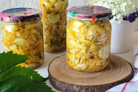 Słoiki z pyszną sałatką z ogórków, marchewki i cebuli na zimę. Idealna do słoików, by cieszyć się smakiem lata przez cały rok.
